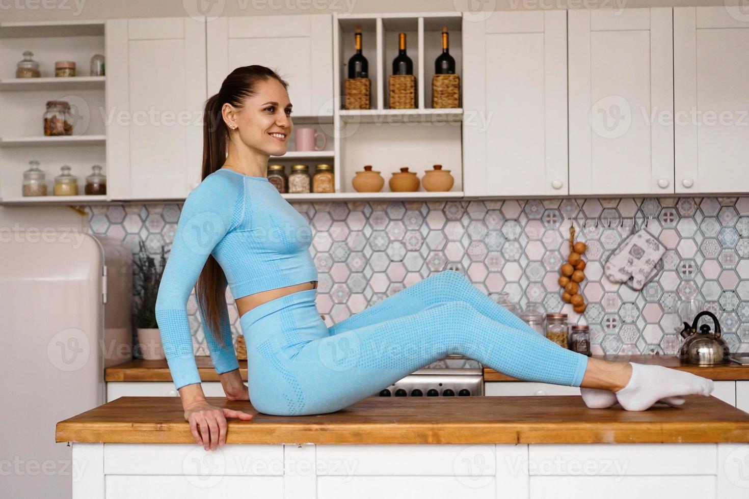 athletische Frau in Sportkleidung posiert auf dem Tisch foto