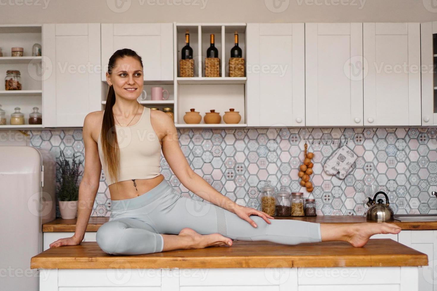 athletische Frau in Sportkleidung posiert auf dem Tisch foto