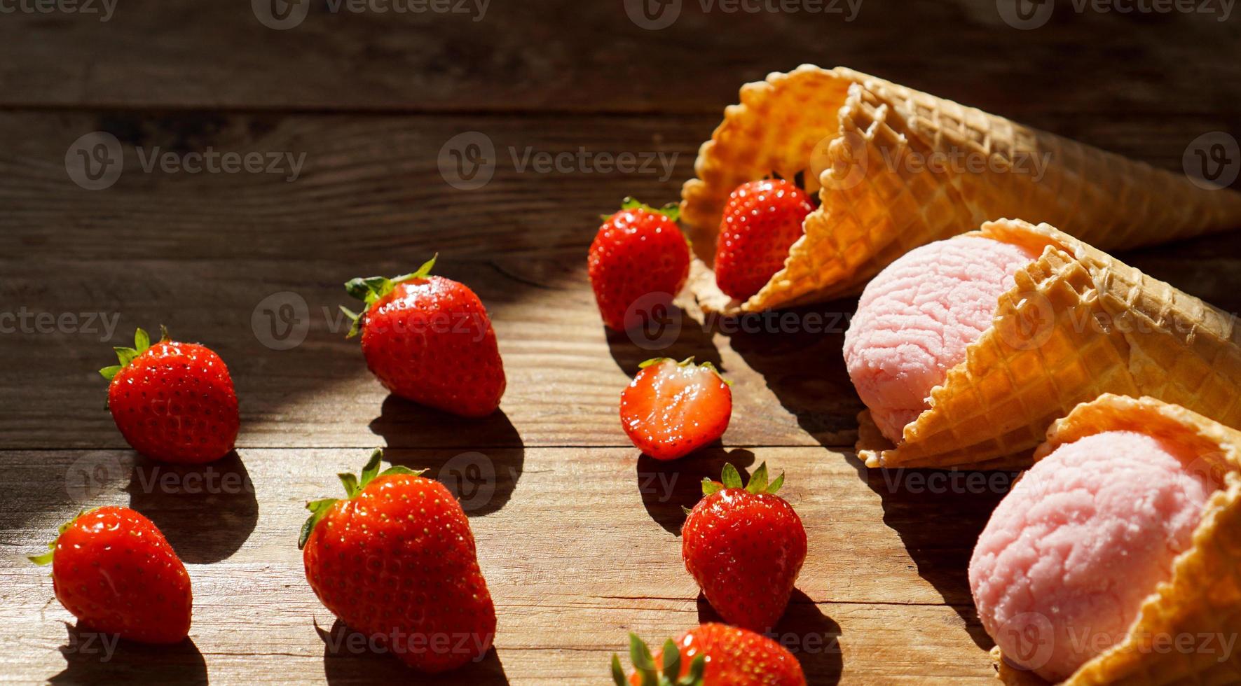 Erdbeereis in einer Waffeltüte. rote Beeren und Eiskugeln foto