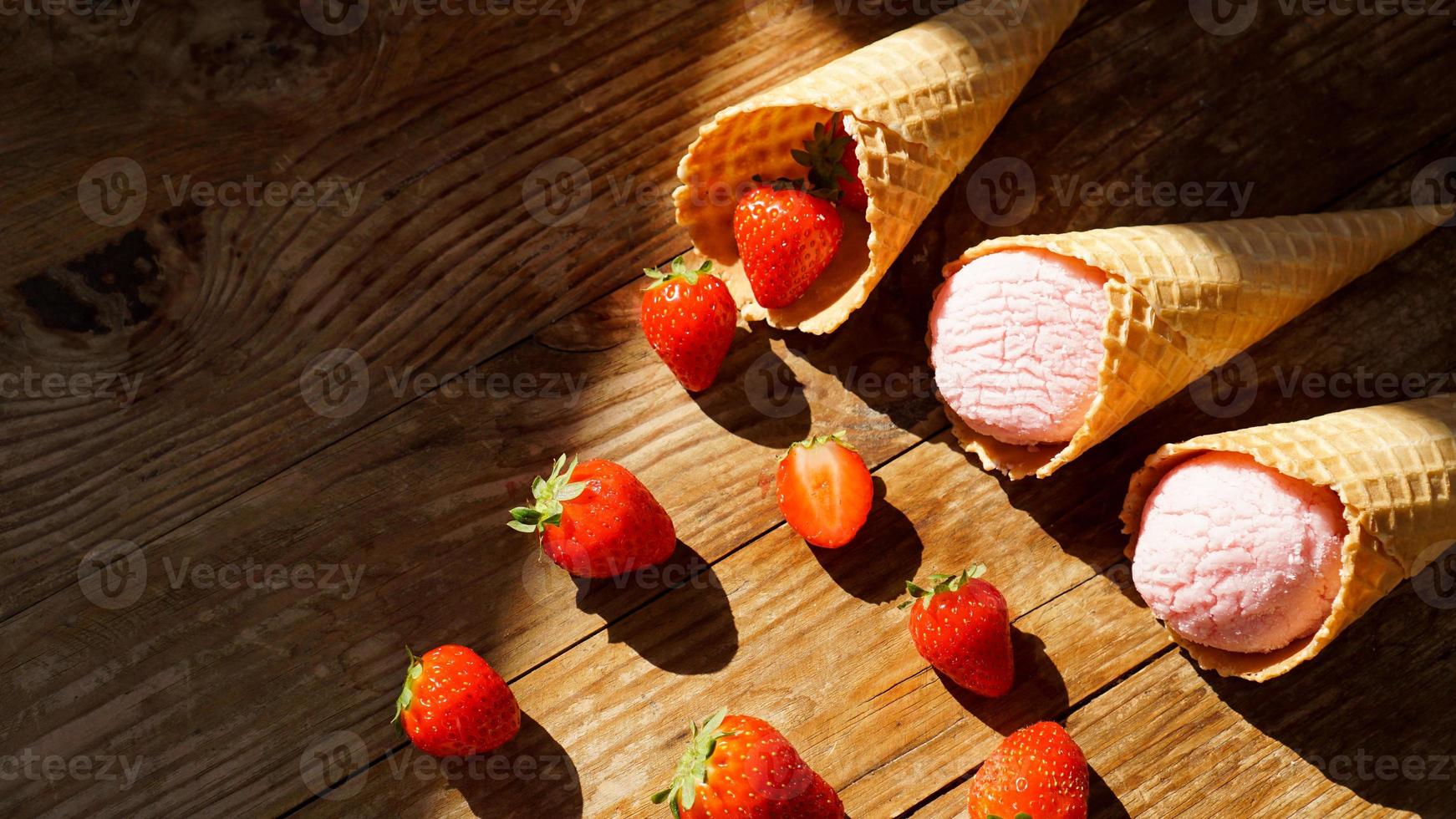 Erdbeereis in einer Waffeltüte. rote Beeren und Eiskugeln foto