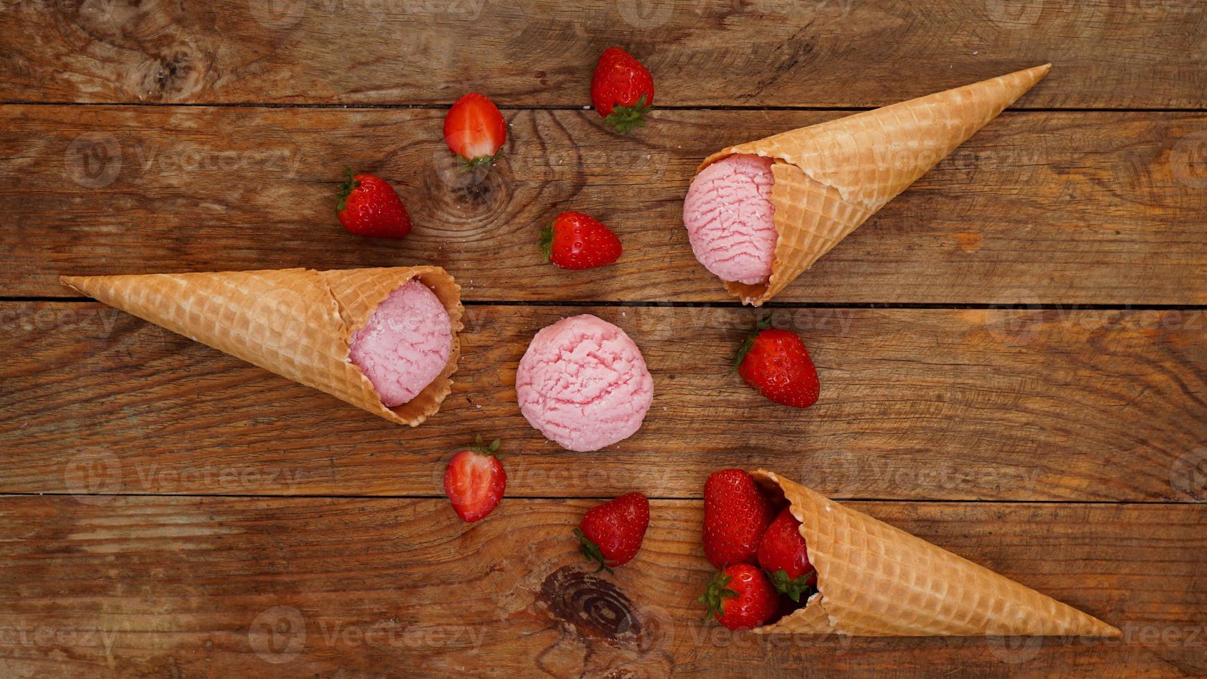 Erdbeereis in einer Waffeltüte. rote Beeren und Eiskugeln foto