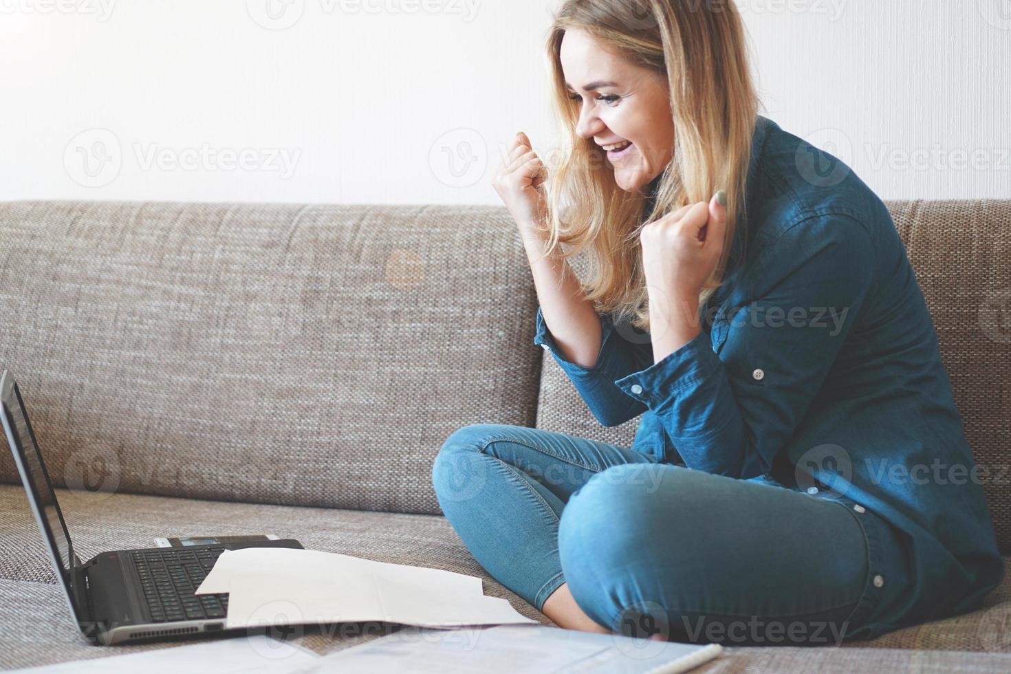 glückliche junge Studentin oder Angestellte, die aufgeregt ist, gute Nachrichten zu lesen foto