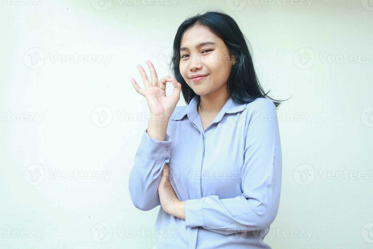 glücklich asiatisch jung Geschäft Frau Show in Ordnung Zeichen Perfektion Geste aussehen Kamera mit Vertrauen lächeln, gefaltet Arm weiblich tragen formal Hemd isoliert Hintergrund foto