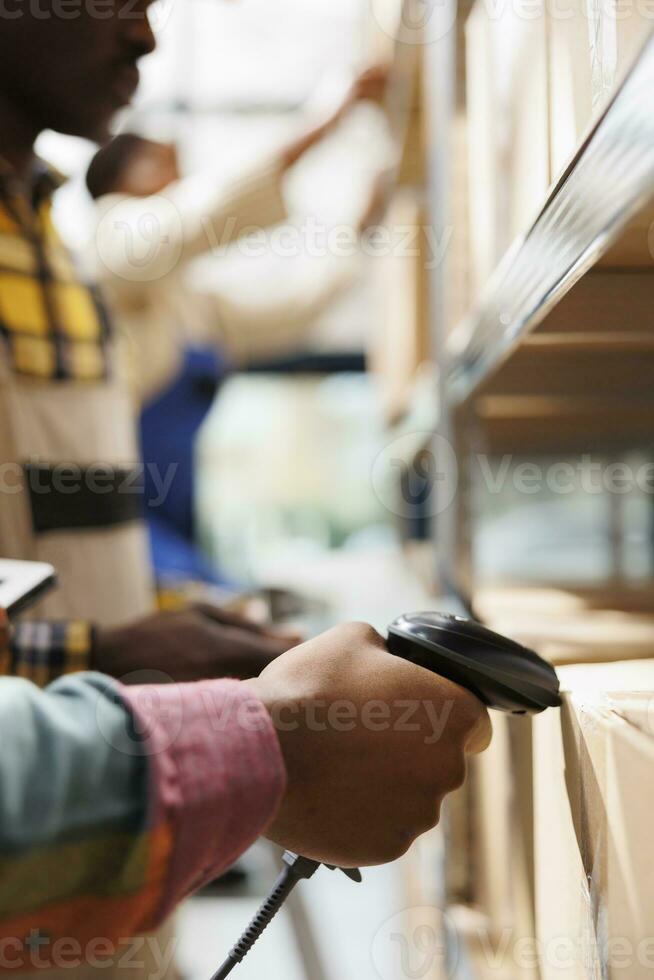 afrikanisch amerikanisch Post- Arbeiter Hand Scannen Paket Barcode im Lagerhaus. Post Büro Lagerhaus Mitarbeiter Arm mit qr Code Scanner Werkzeug auf Kunde Paket Vor Lieferung schließen oben foto