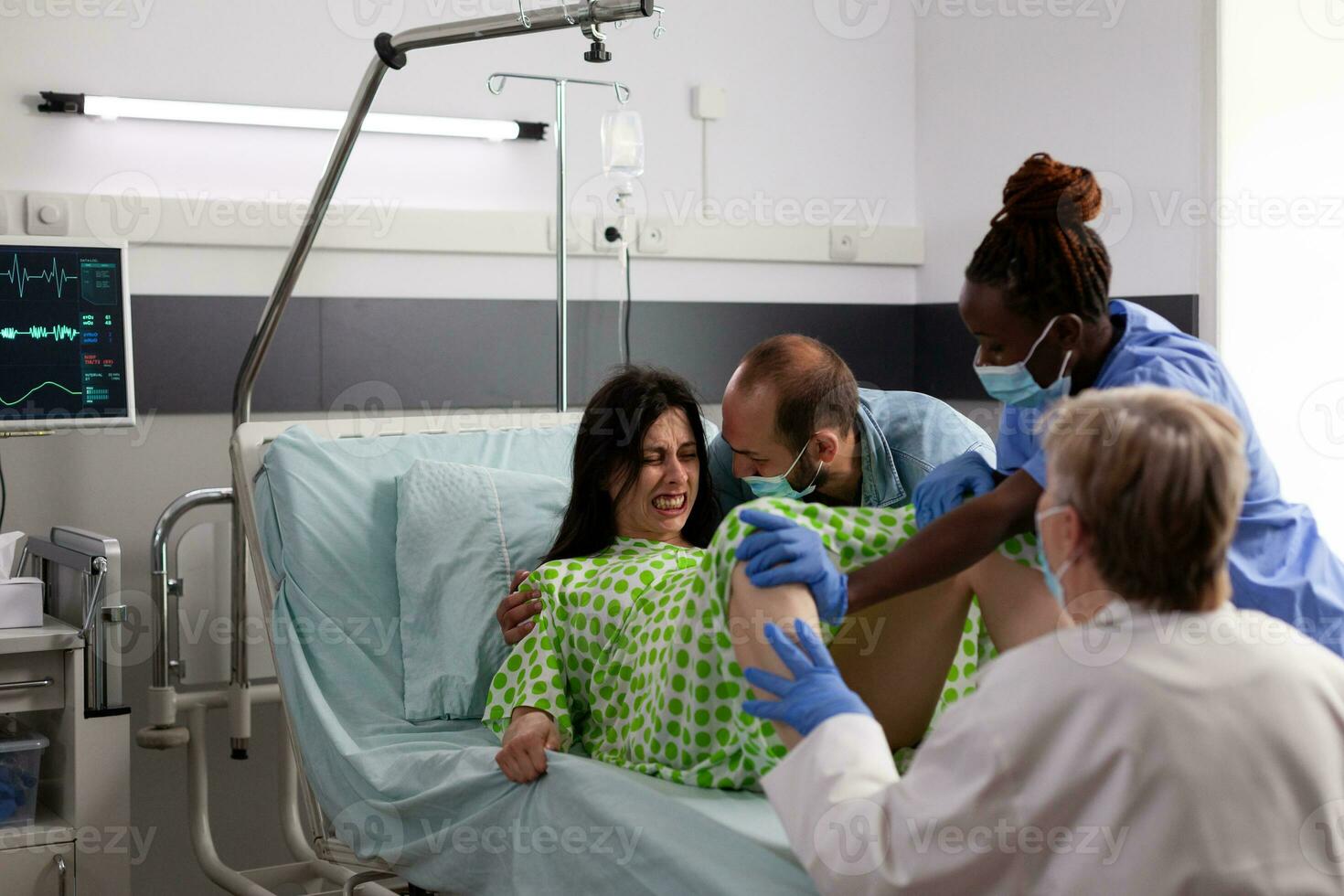 vielfältig Geburtshelfer Arzt Portion Frau zu Lieferung Baby, Sein wohltuend durch Mann im Krankenhaus Station. schwanger geduldig mit schmerzlich Arbeit Kontraktionen schieben während geben Geburt zu Kind foto