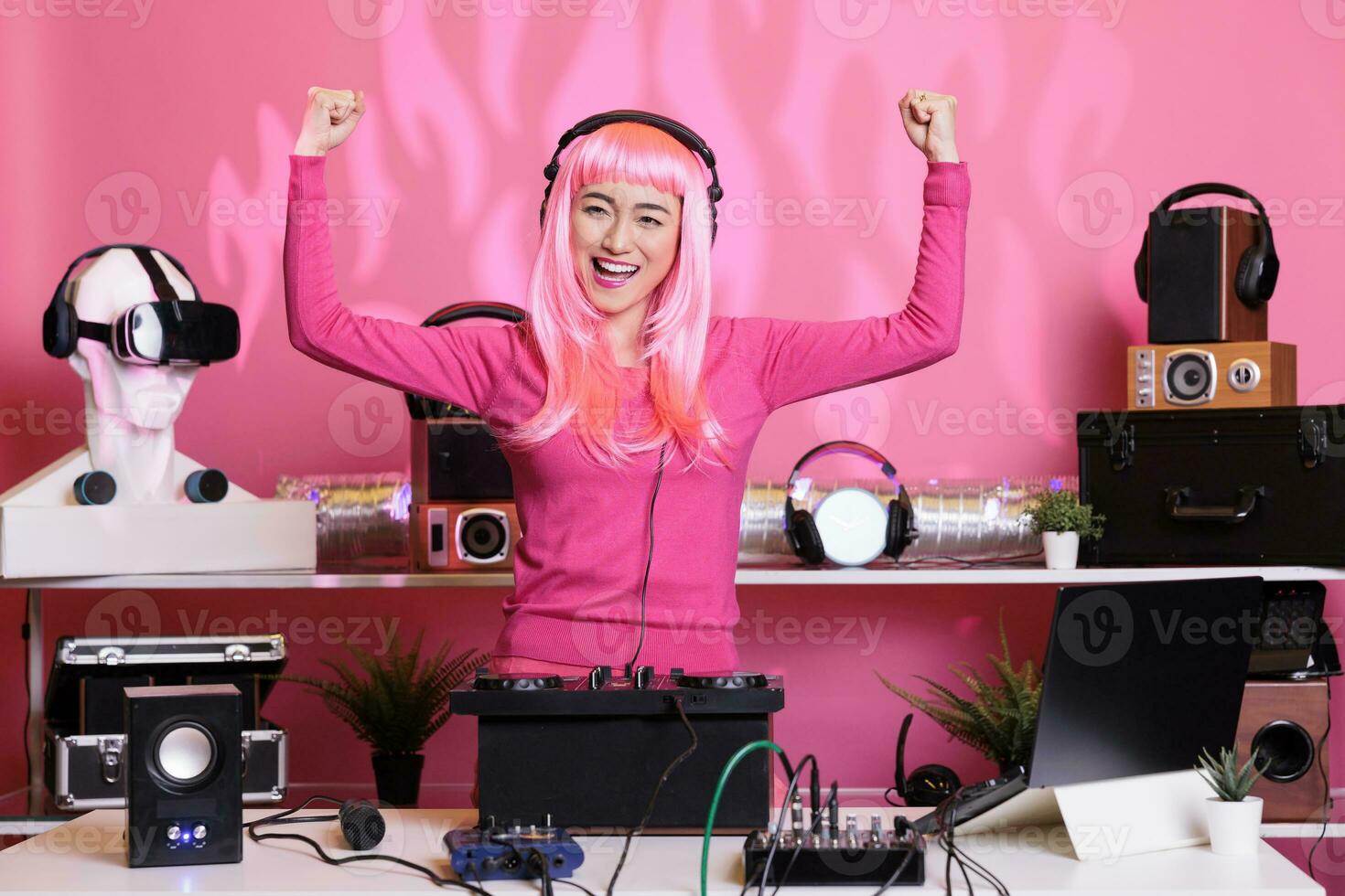 Künstler mit Rosa Haar durchführen Techno Musik- mit dj Rührgerät Konsole genießen zu abspielen Lied mit Fans, haben Spaß im Verein beim Nacht. Künstler tun Performance mit Fachmann Audio- Ausrüstung foto