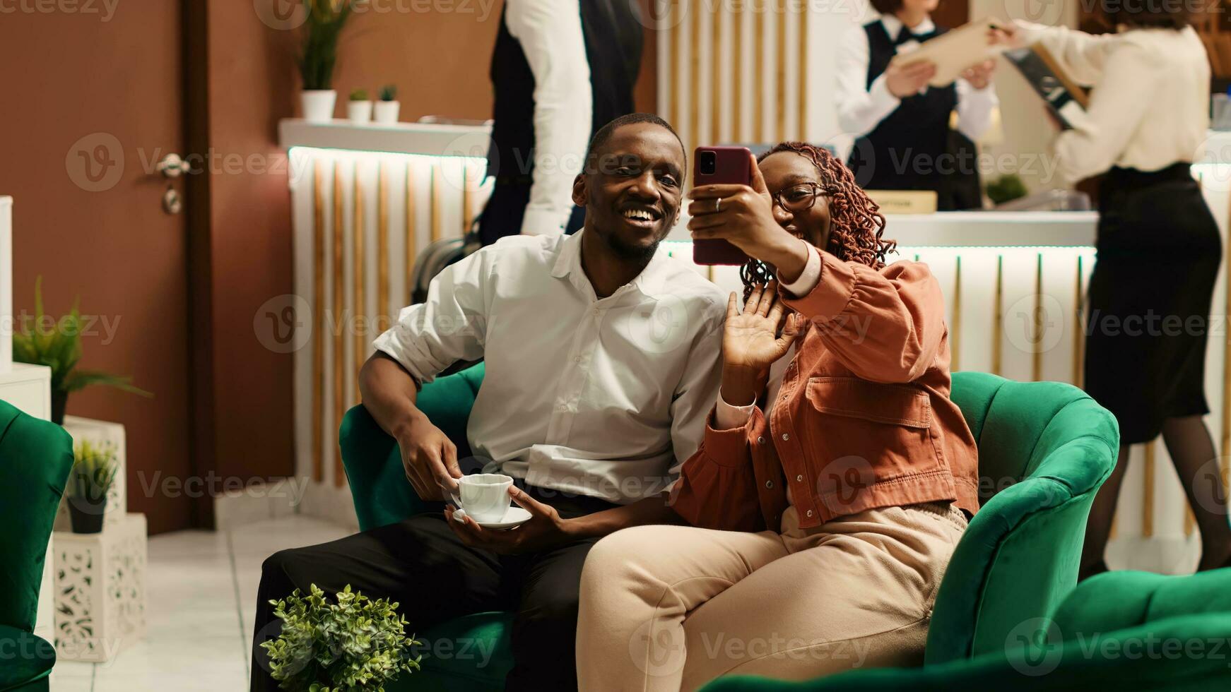 glücklich Paar auf ihr Flitterwochen Ferien im Video Anruf mit Familie während genießen Tasse von Kaffee im Hotel Salon. heiter Mann und Ehefrau im Videokonferenz mit Verwandtschaft während Weg auf Hochzeit Ausflug foto