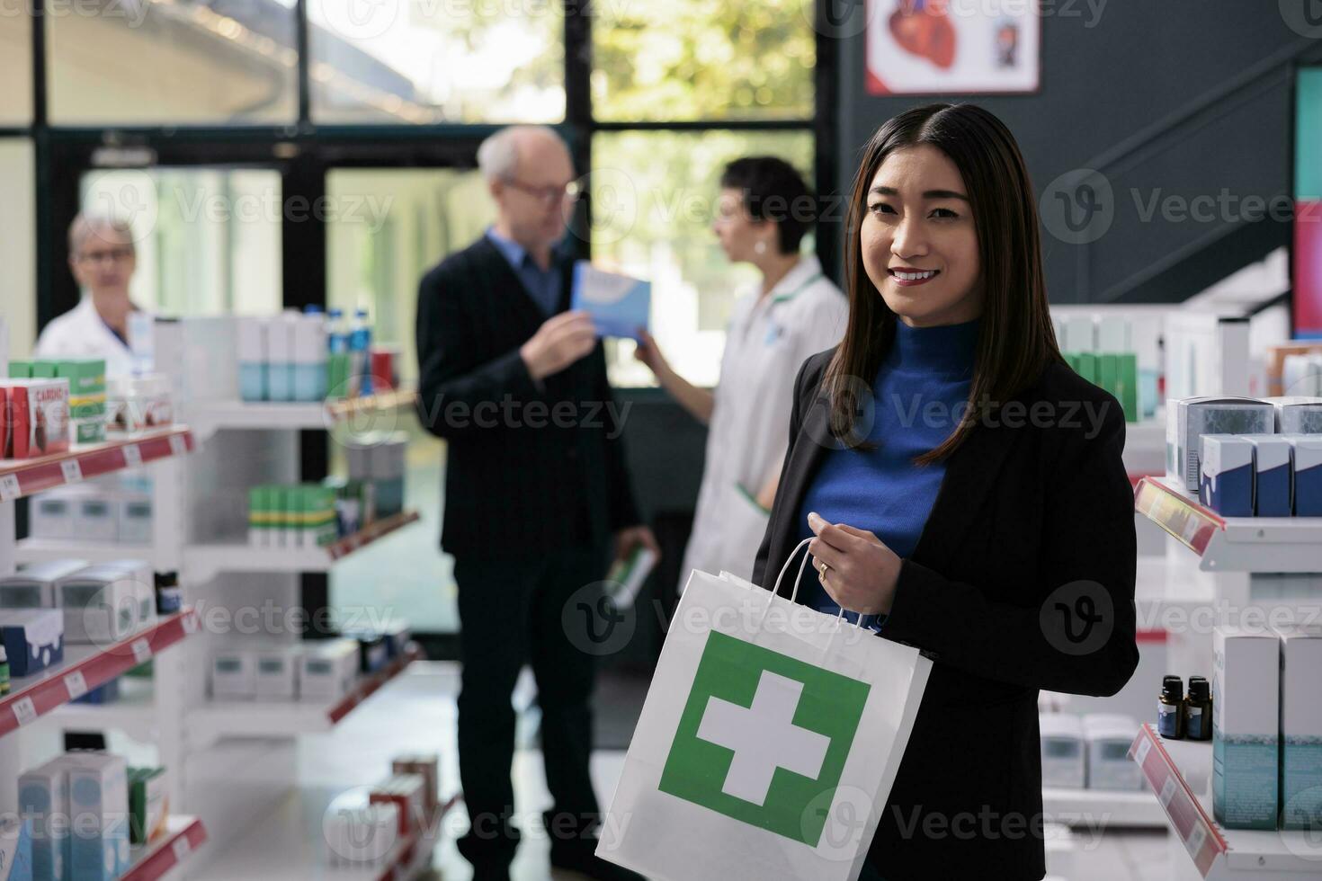 lächelnd asiatisch Frau Kauf Medikation im Drogerie und halten Kauf Porträt. Apotheke Geschäft jung Käufer Stehen in der Nähe von Regal mit Medikament und Tragen Einkaufen Papier Tasche foto