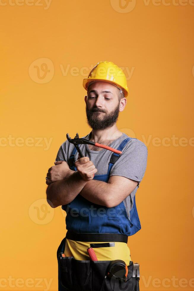 Fachmann Handwerker halten Paar von Zange zu Arbeit auf Haus Renovierung, Stehen im Studio. Konstruktion Arbeiter Vorarbeiter mit Zange und Sanierung Werkzeug, industriell Maschinenbau. foto