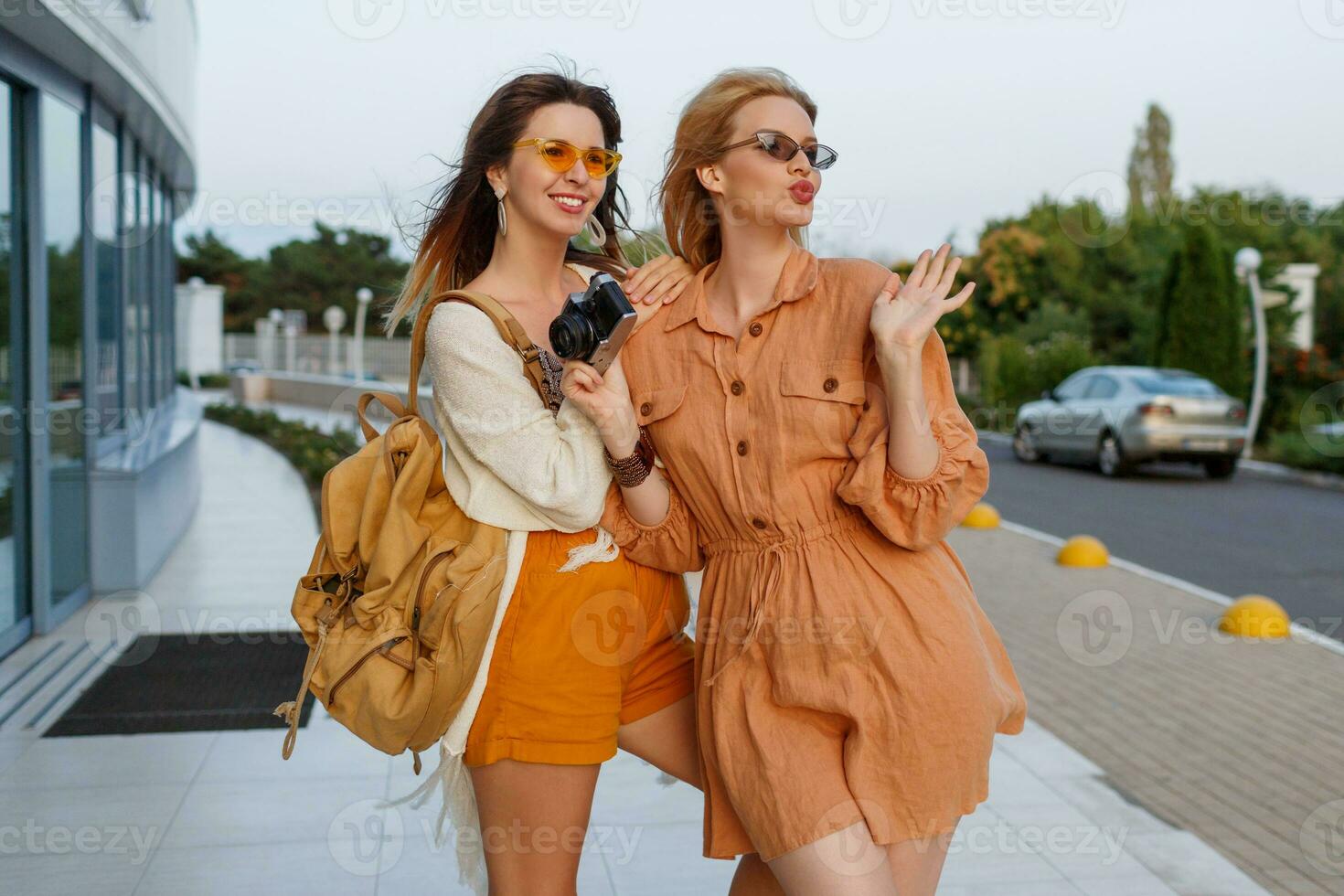 Paar von stilvoll Frauen nach verlassen Ausflug und Einkaufen posieren draussen in der Nähe von Flughafen. modisch Leinen- Kleider und Boho Kleid. foto