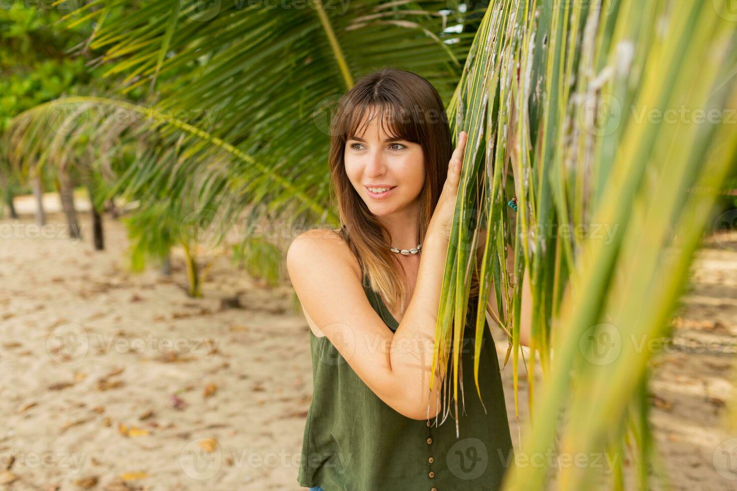 Sommer- Foto von natürlich Weiß Frau posieren auf das Strand in der Nähe von Palme Bäume.