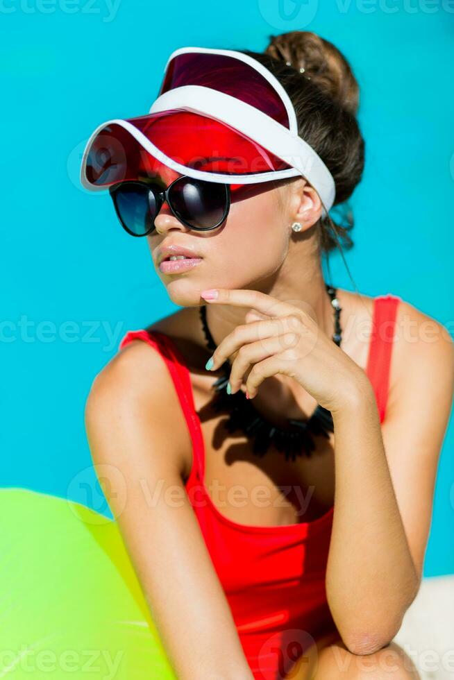 sexy Braun gebrannt Frau im rot Badeanzug haben Spaß und genießen Sommer- im tolle groß Schwimmen Schwimmbad. stilvoll transparent Deckel. Strand Party. foto