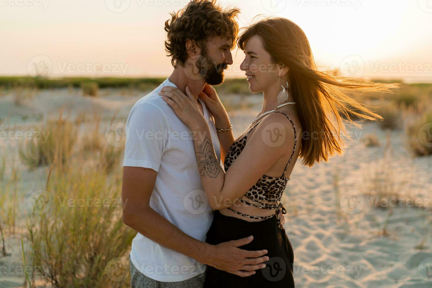 schön Paar im Liebe posieren auf tropisch Strand. gut aussehend Mann mit Bart umarmen seine Freundin. tropisch Boho Outfit. foto