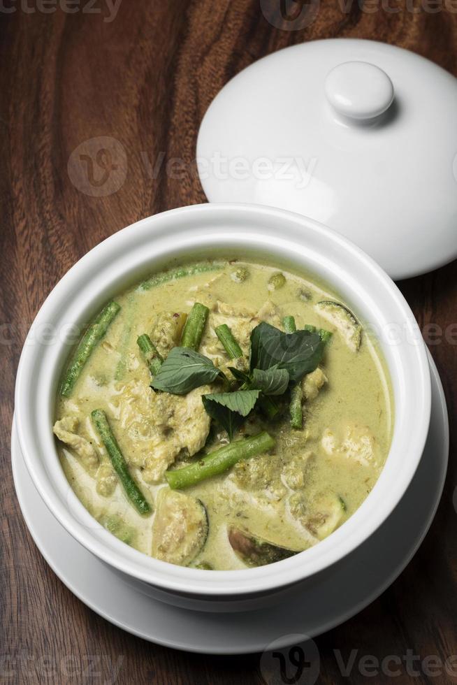 thailändisches grünes Curry mit Hühnchen und Gemüse auf Holztisch foto