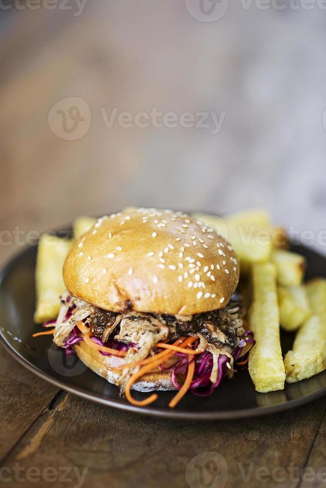 Gourmet-Sandwich mit Pulled Pork und eingelegtem Gemüse mit Pommes frites foto