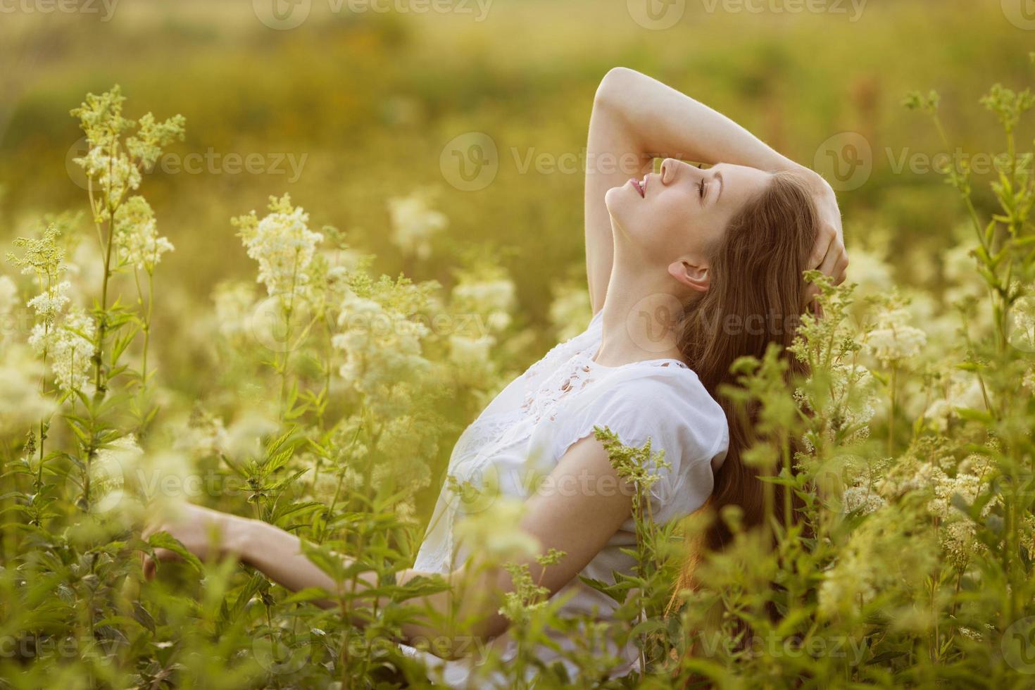 glückliche junge Frau mit hohen Wildblumen foto