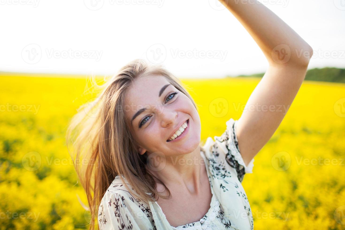 schöne Frau zwischen gelben Blumen auf einem Feld foto