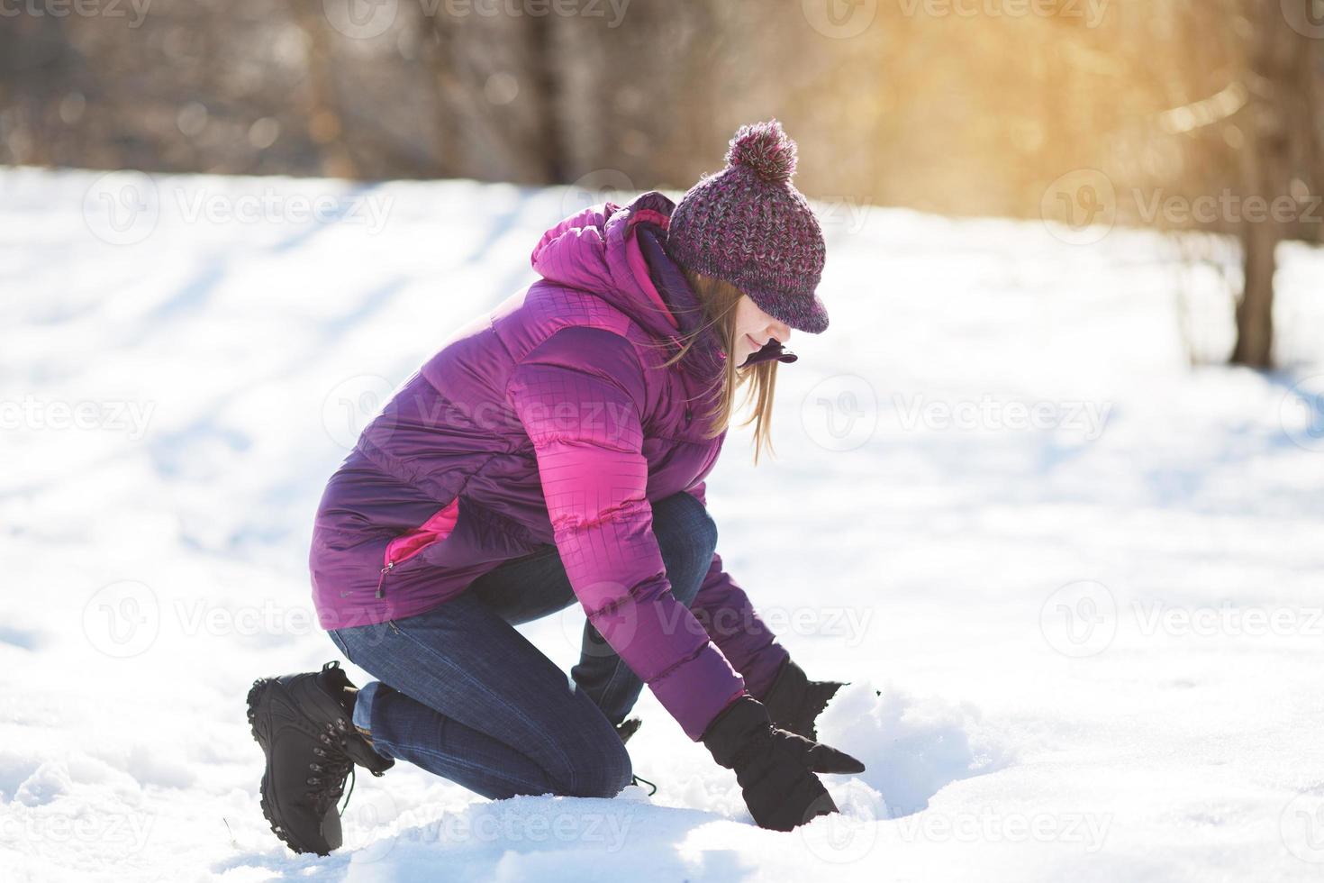 junge Frau nimmt Schnee mit den Händen foto