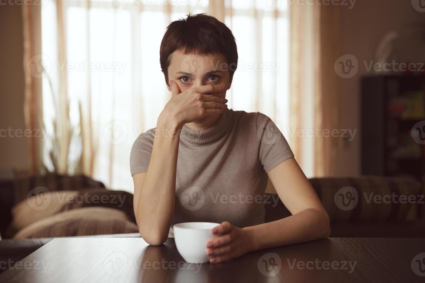 Frau bedeckte ihr Gesicht mit seiner Hand foto