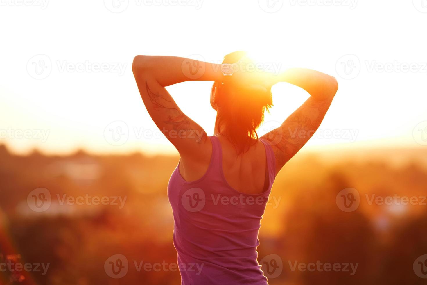 glückliche junge Frau bei Sonnenuntergang foto