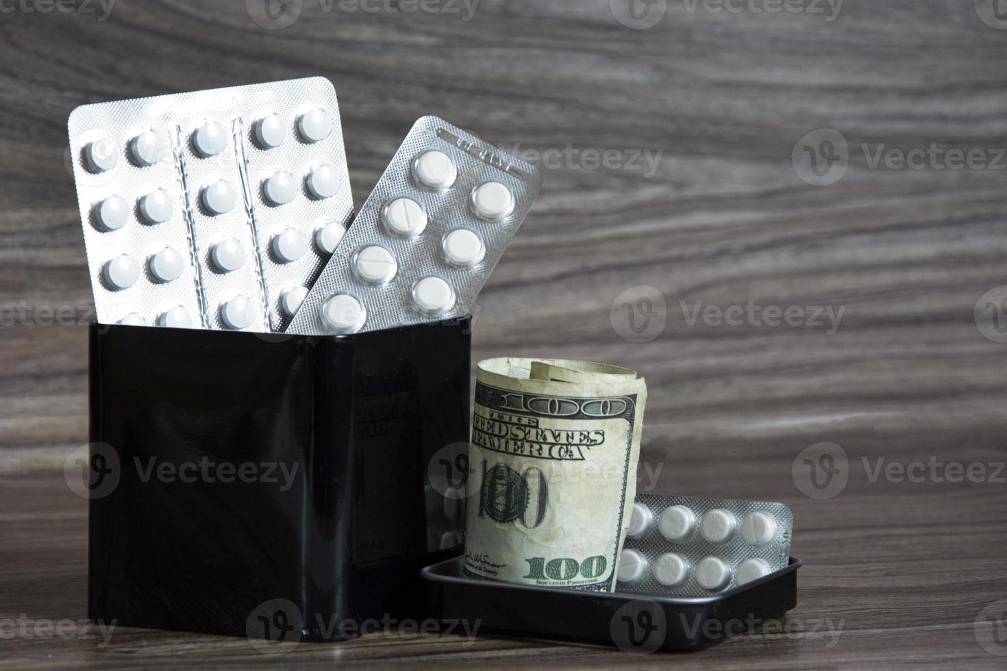 bezahlte Medizin. Tabletten und Dollar in einer Blechdose. Gesundheitskonzept foto