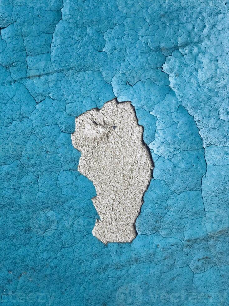 alt Beton Mauer bedeckt mit Blau Farbe mit Risse wie ein Hintergrund Oberfläche foto