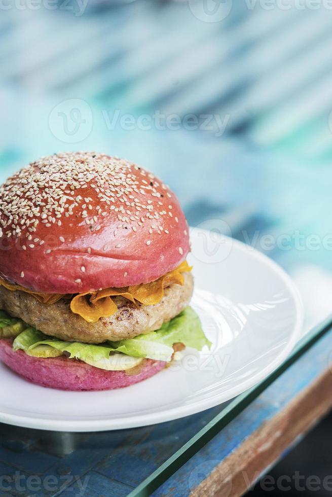 moderner Gourmet-Trend Chicken Burger im Rote-Bete-Brötchen foto