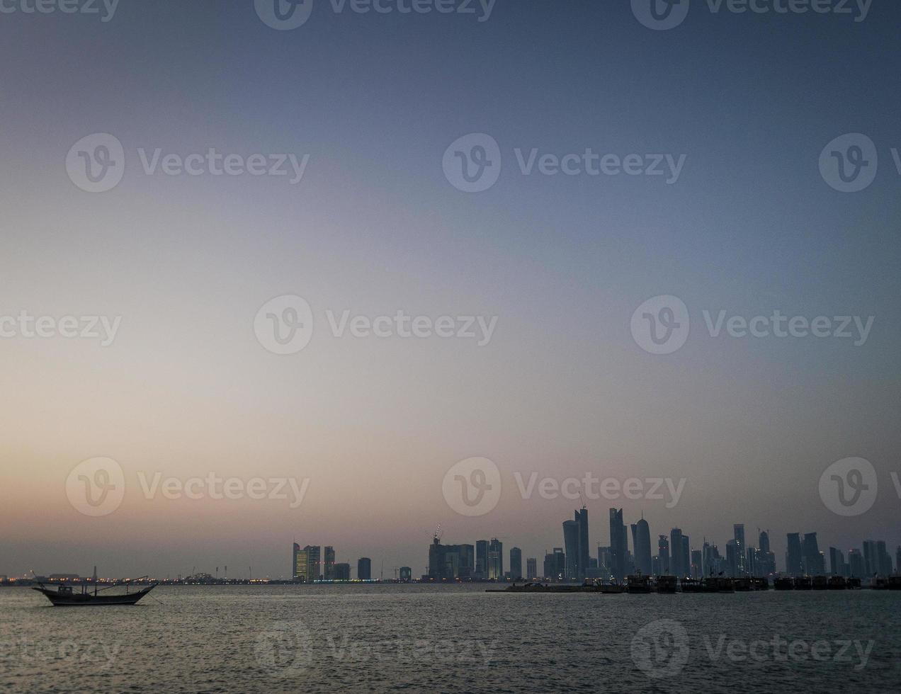 Doha-Stadt-Wolkenkratzer mit Blick auf die städtische Skyline und Dhow-Boot in Katar foto