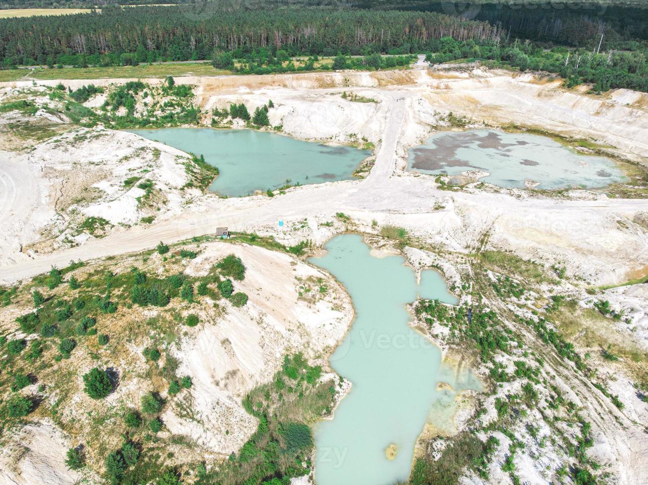 Drohnenblick auf einen überfluteten Kaolin-Steinbruch, türkisfarbenes Wasser und weißes Ufer foto