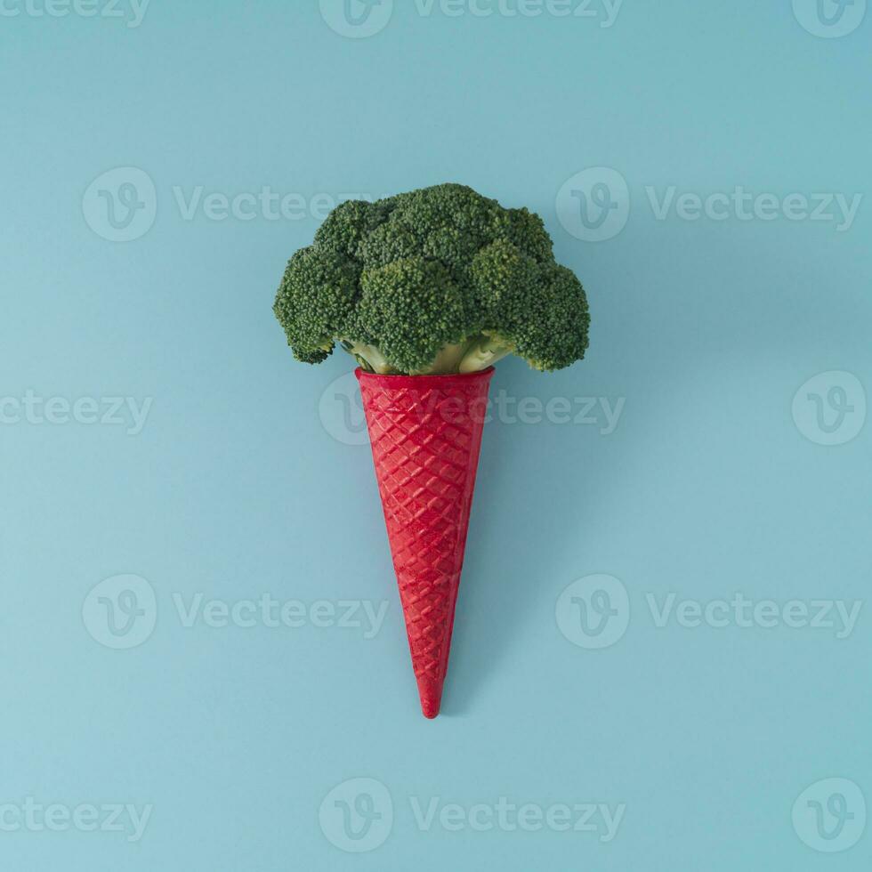 Rosa Waffel Eis Sahne Kegel mit Brokkoli auf Licht Blau Hintergrund. minimal Essen Konzept. Sommer- kreativ Idee. lecker Gemüse Layout. Eis Sahne eben legen Komposition. foto