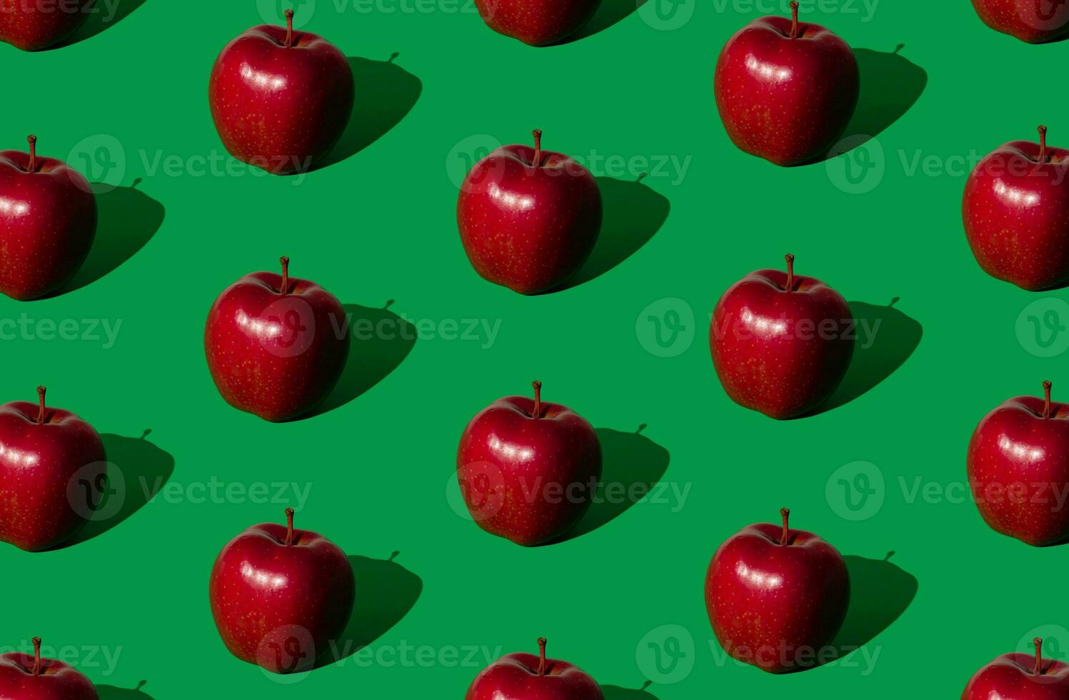 modisch Obst Muster gemacht von rot Äpfel auf Fett gedruckt Grün Hintergrund. Natur kreativ Konzept. minimal Layout. foto