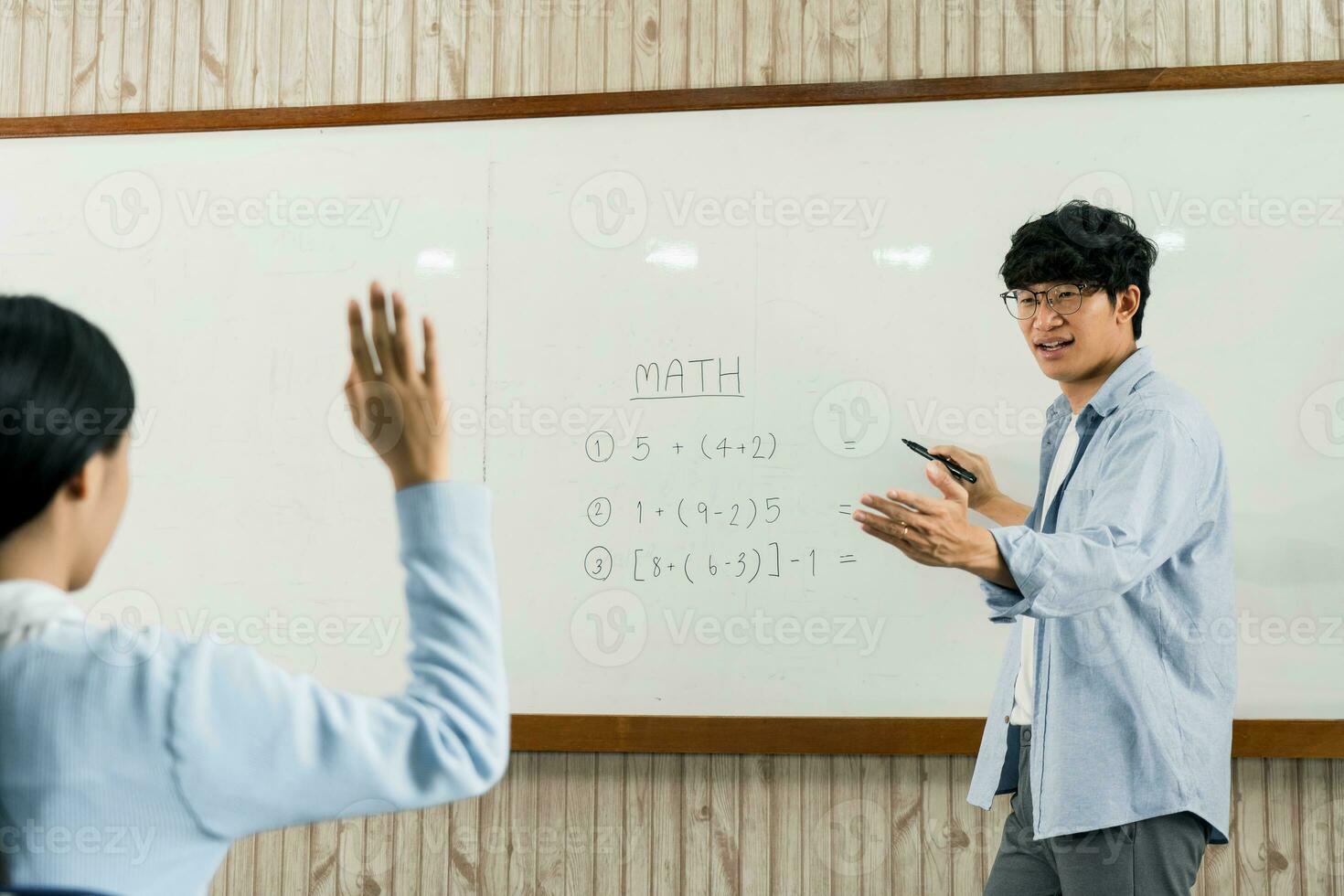 asiatischer männlicher lehrer, der schüler im klassenzimmer unterrichtet foto