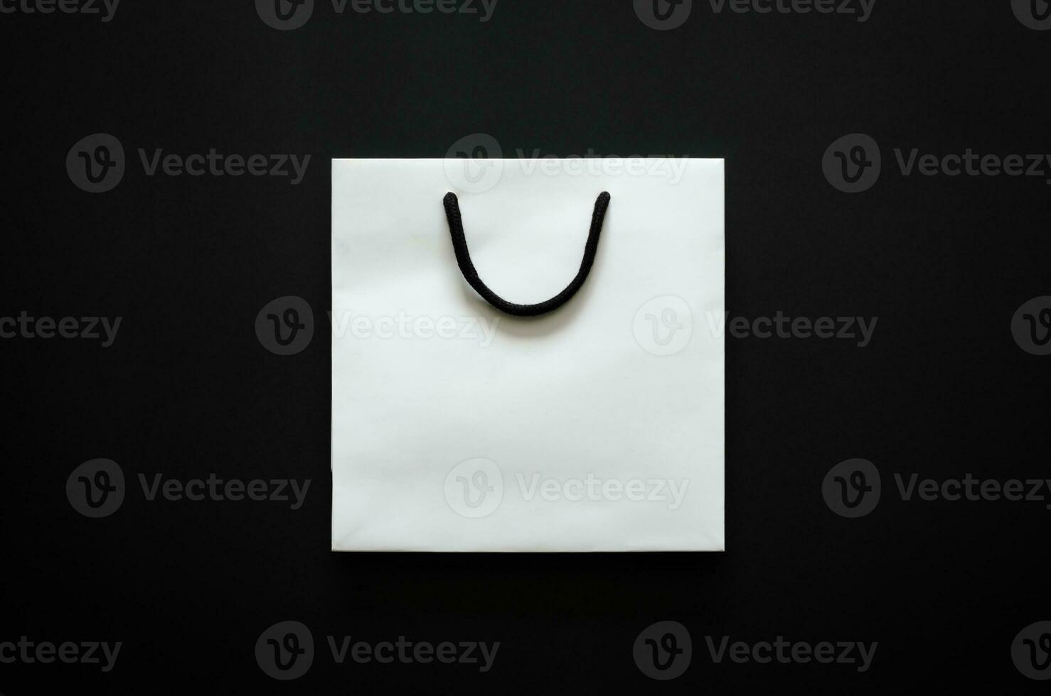 Weiß Einkaufen Papier Tasche auf schwarz Hintergrund zum schwarz Freitag Einkaufen Verkauf Konzept. foto