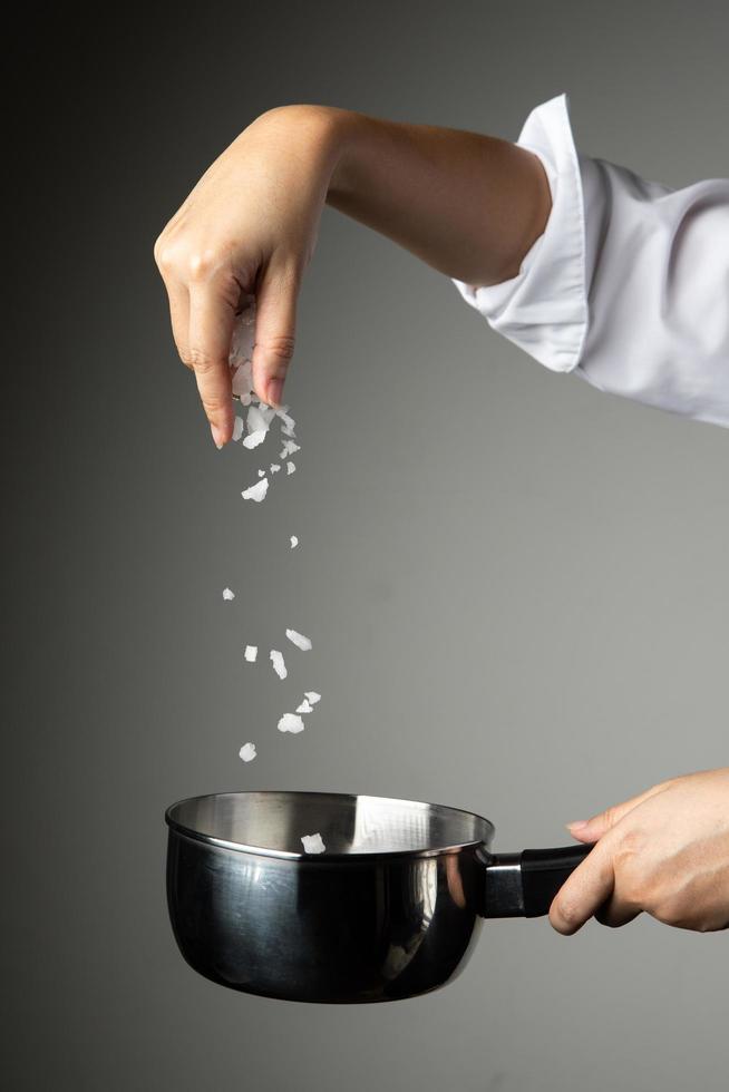 Koch Frau streuen Salz kochen Essen zubereiten würzen foto