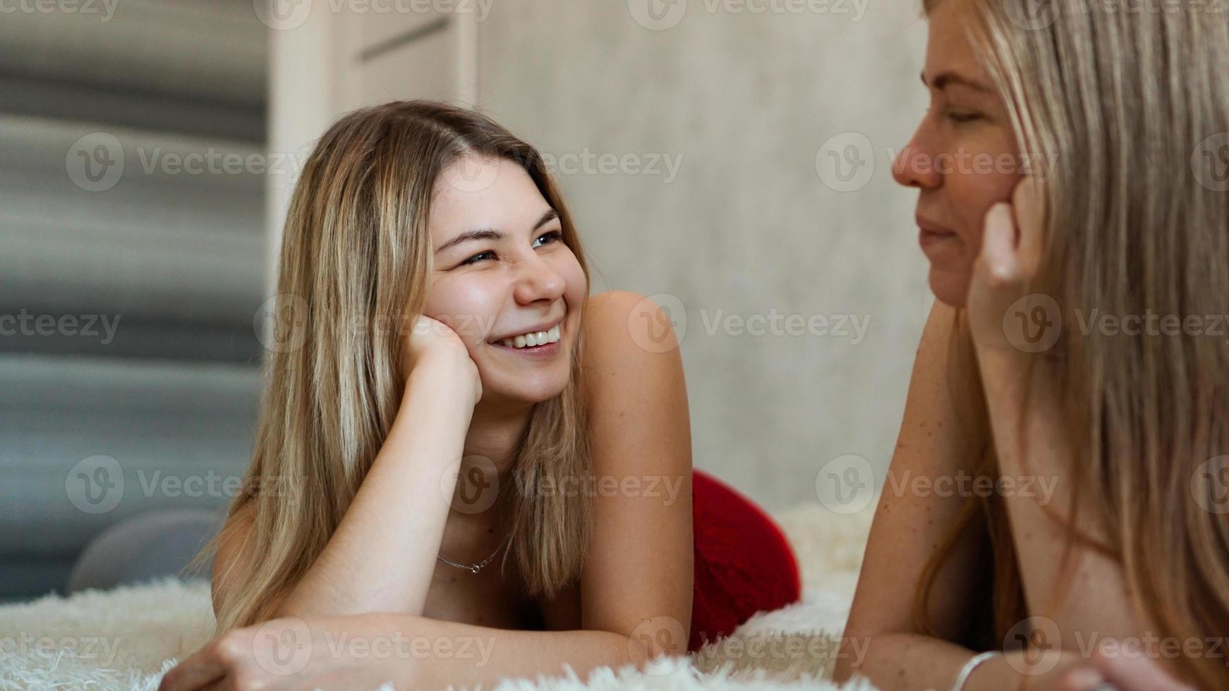 glückliche Freunde, die im Bett liegen und lachen foto