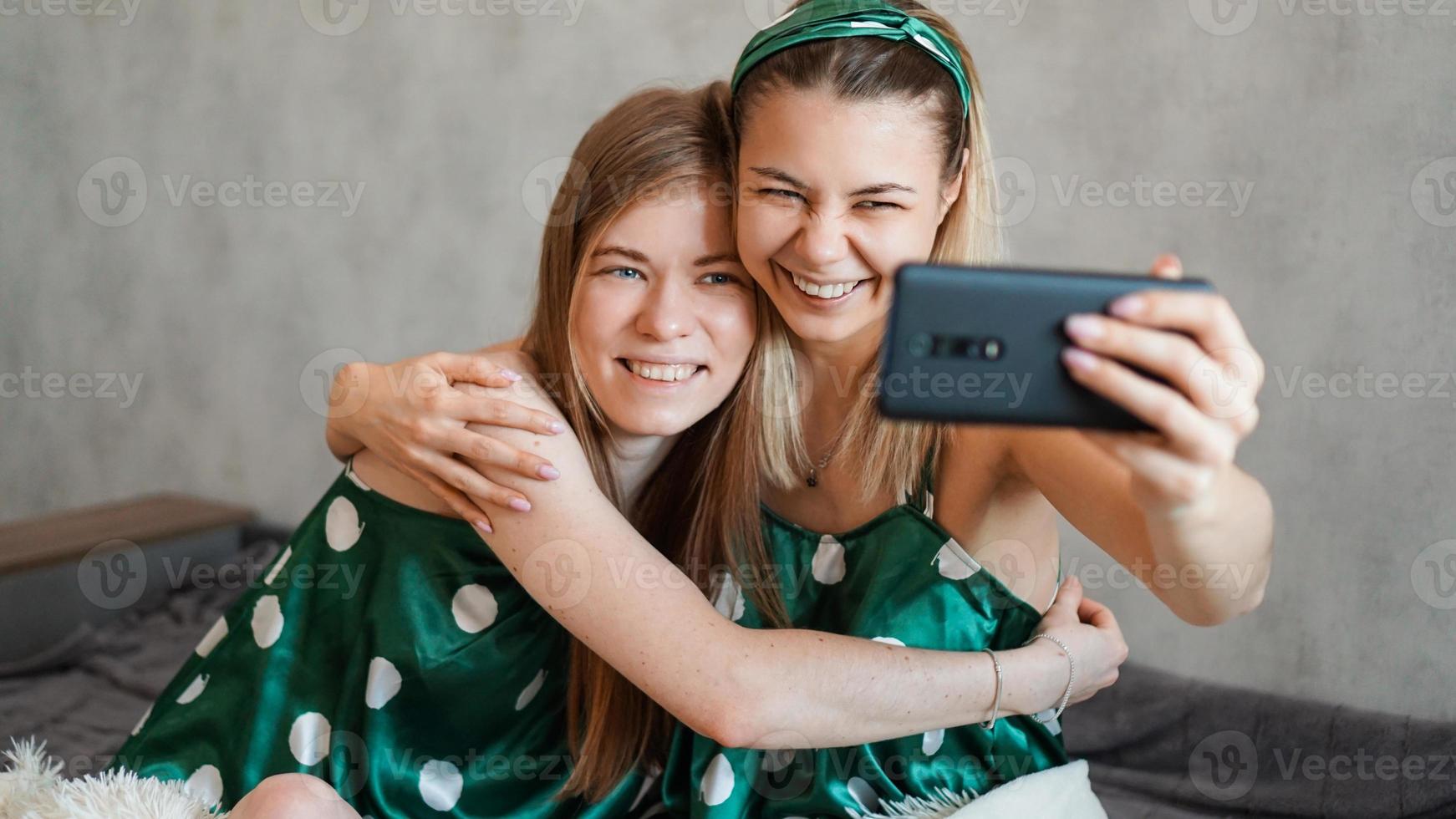 schöne glückliche Freundinnen, die Selfie mit Smartphone machen foto