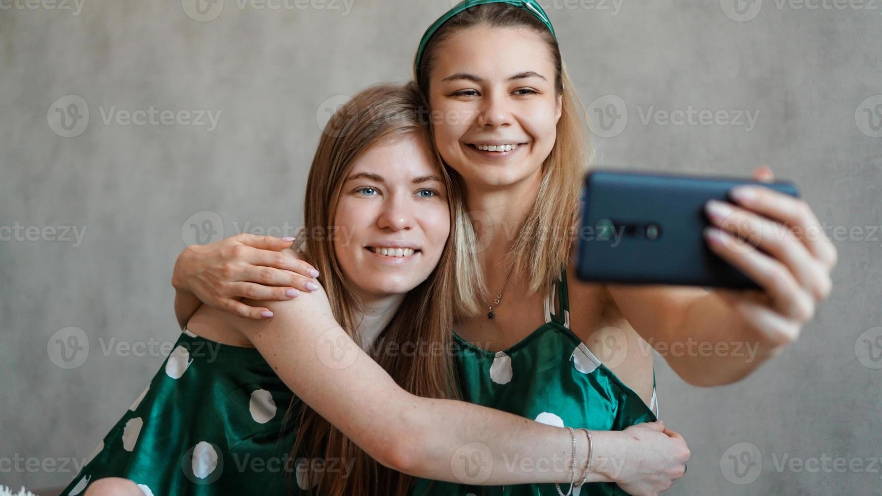 schöne glückliche Freundinnen, die Selfie mit Smartphone machen foto