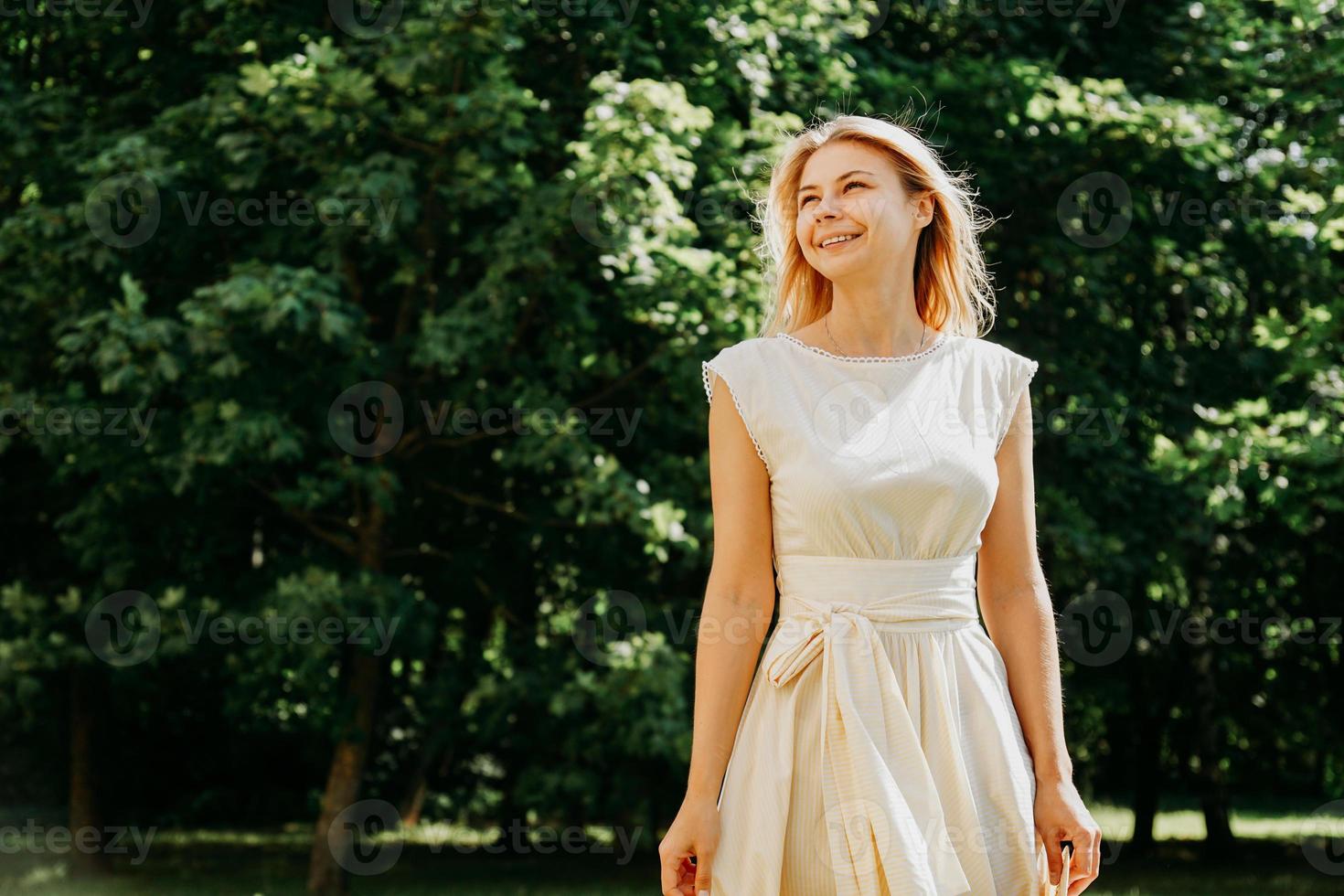 attraktive junge frau, die ihre zeit draußen im park genießt. foto