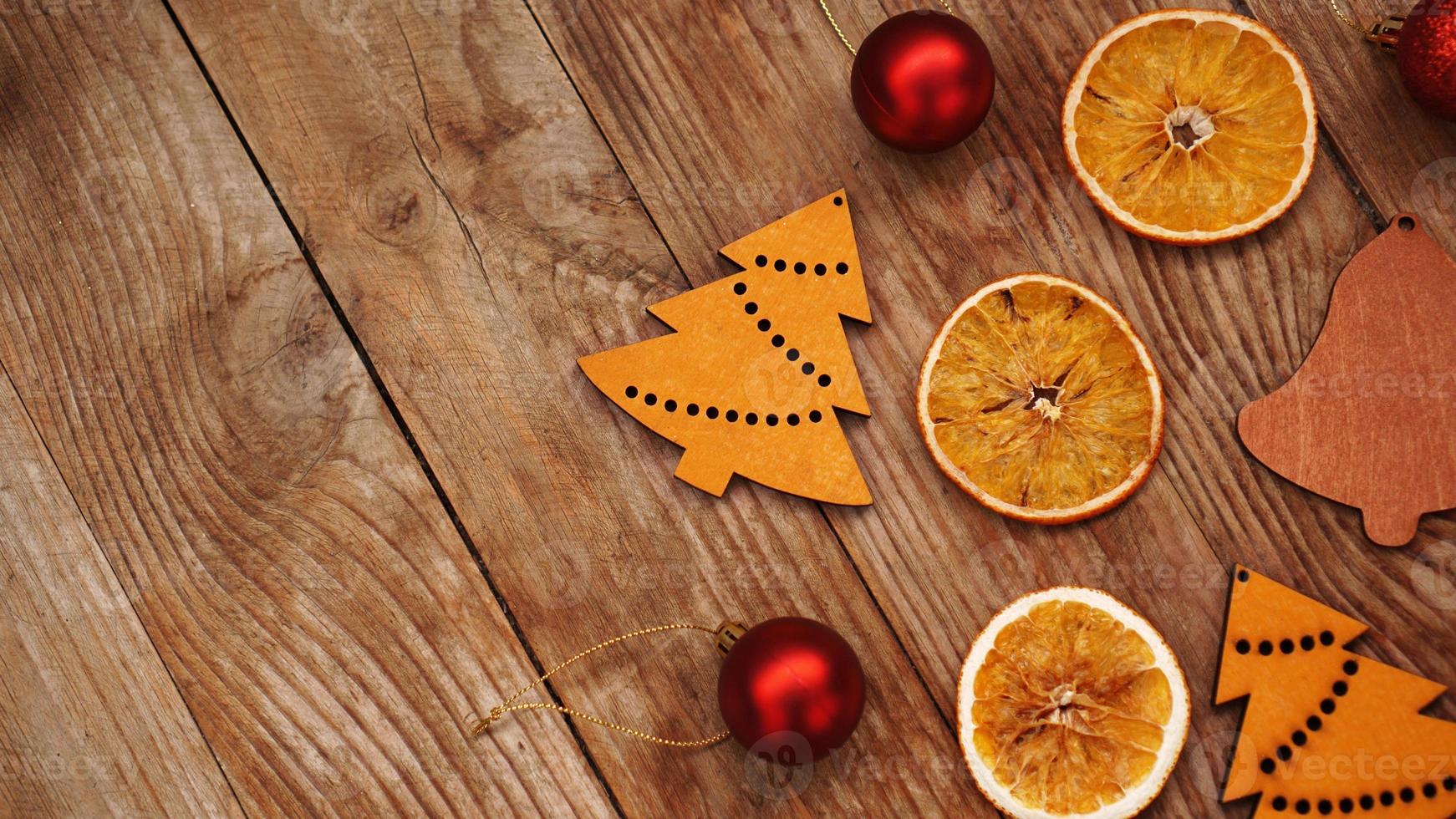 Trockene Orangen, rote Kugeln und Weihnachtsfiguren aus Holz foto