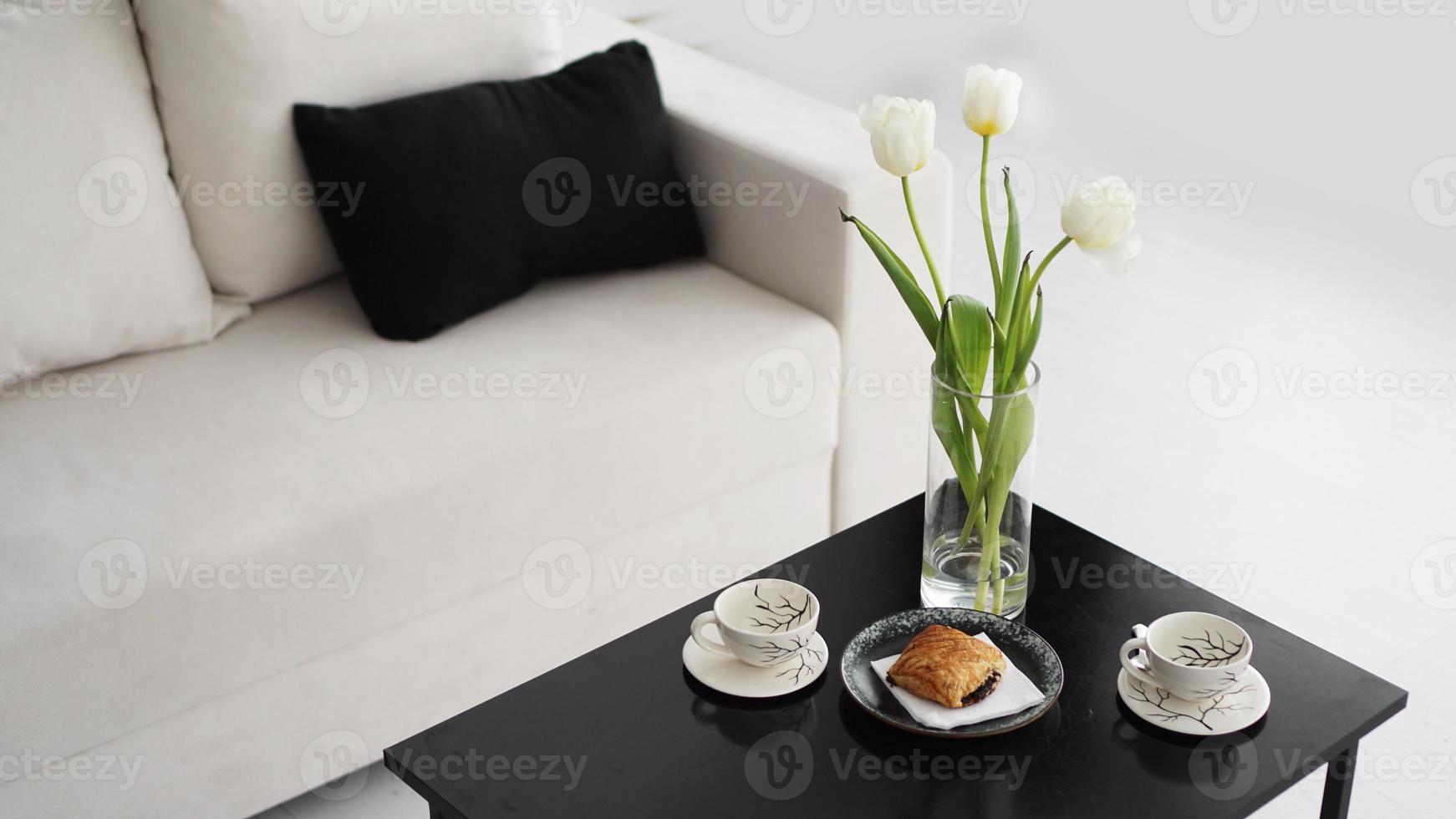 Sofa in einem modernen Interieur. auf dem Tisch liegt ein Strauß Tulpen foto