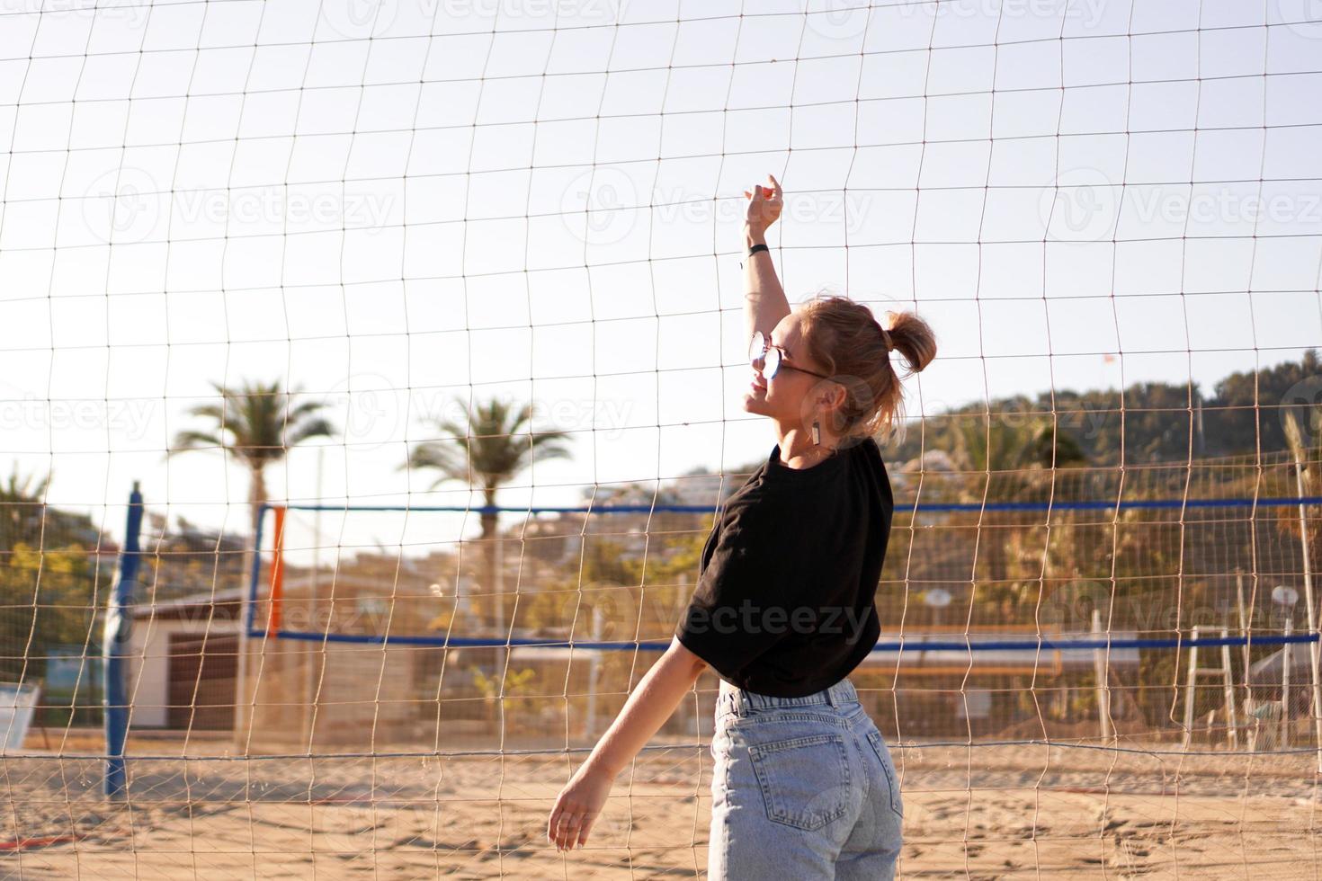 Porträt einer attraktiven Frau in der Nähe des Volleyballnetzes am Strand foto
