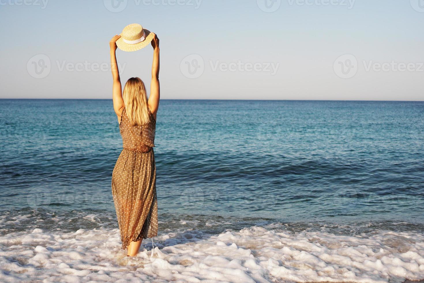 Frau am Strand in einem braunen Kleid foto