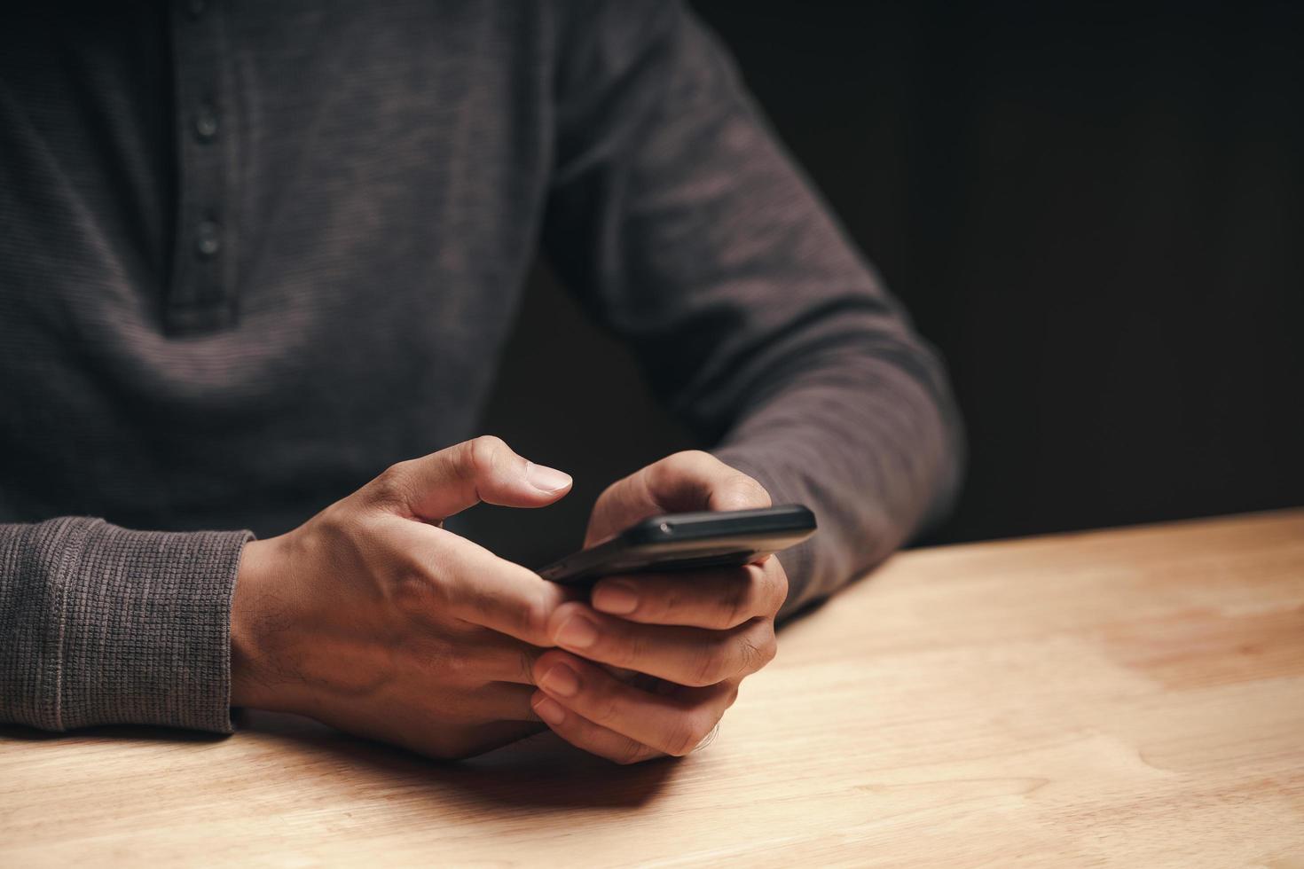 Mann mit einem Smartphone auf dem Tisch, Suchen, Surfen, Social Media foto