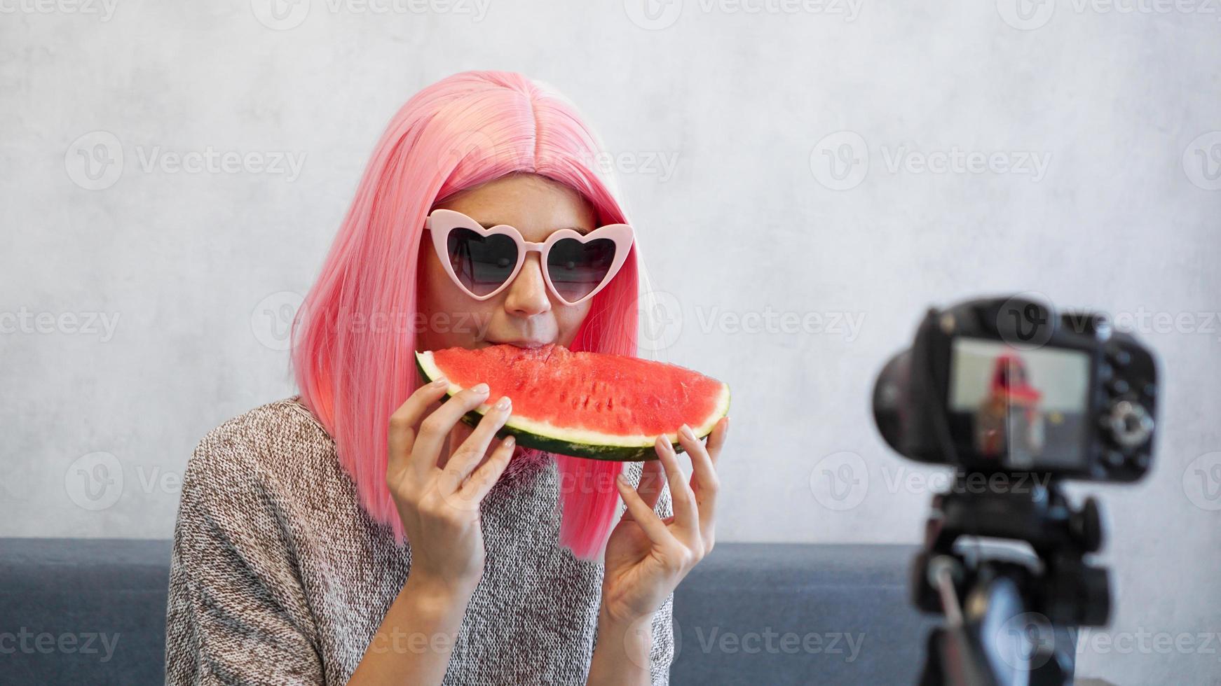 Blogger nimmt ein Video über gesunde Ernährung auf und hält eine Wassermelone foto