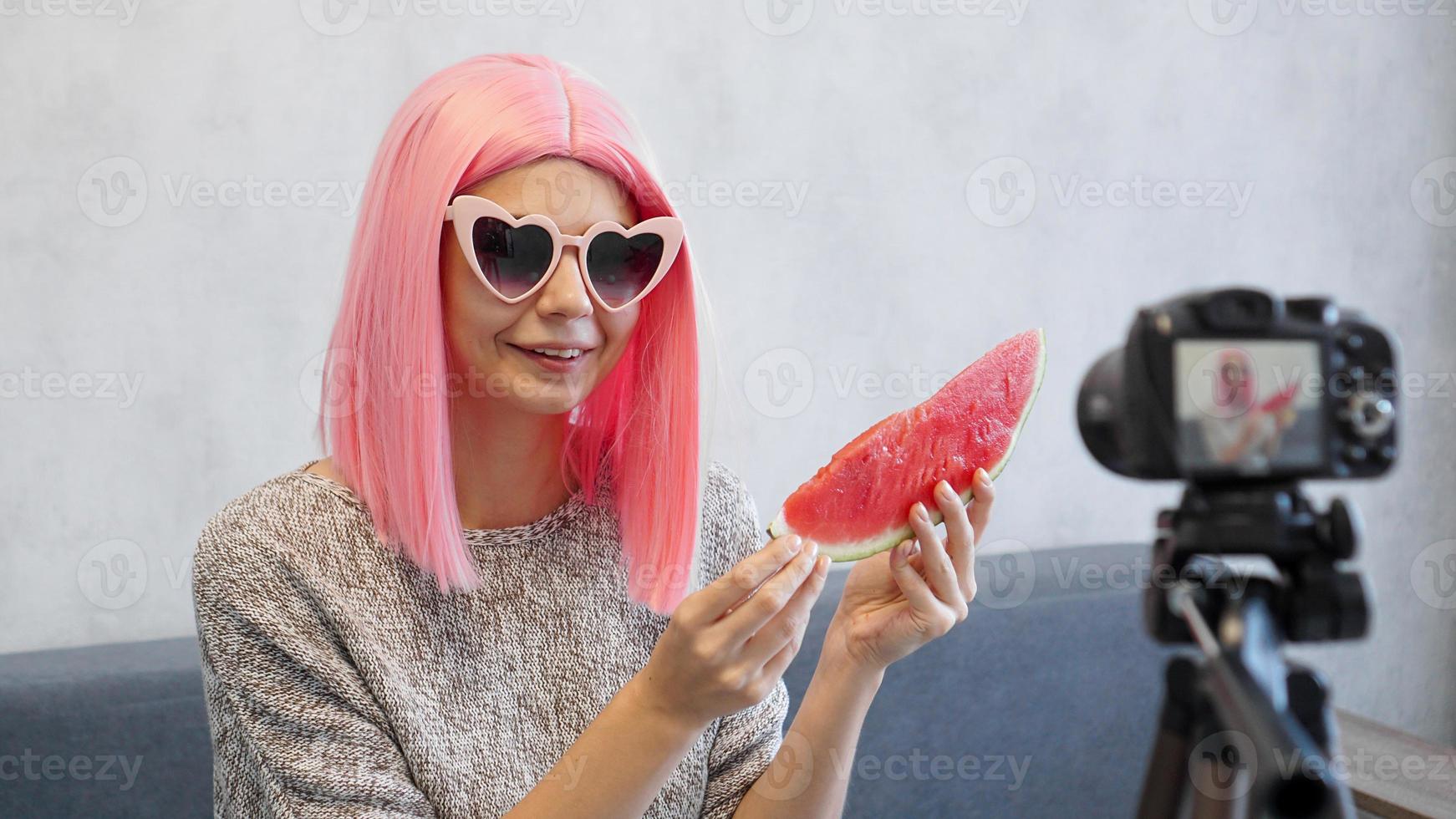 Blogger nimmt ein Video über gesunde Ernährung auf und hält eine Wassermelone foto