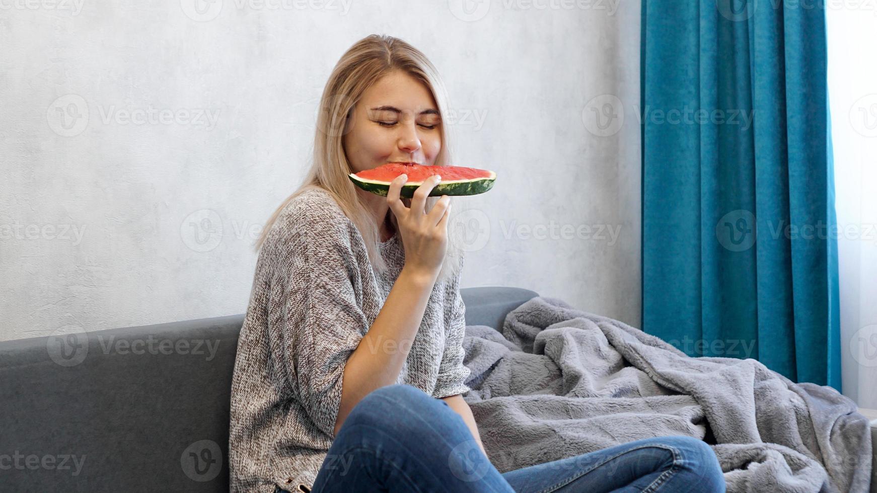 junge attraktive Frau, die Wassermelone isst. Frau zu Hause foto