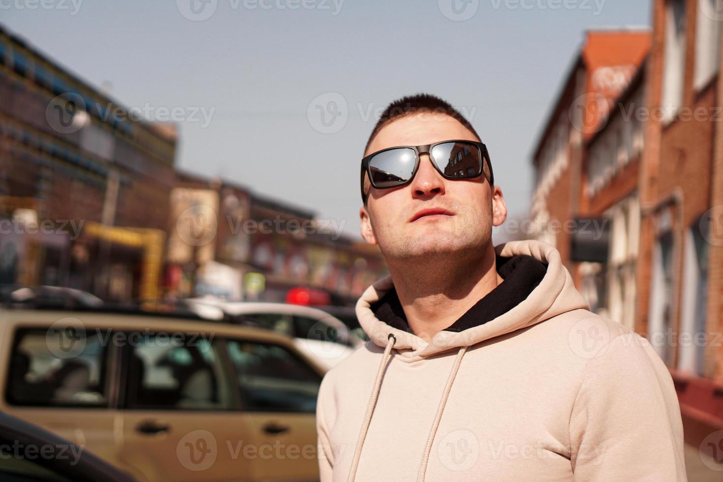 Hipster-Mann auf der Straße mit rotem Backsteinmauergebäude im Sommertag. foto