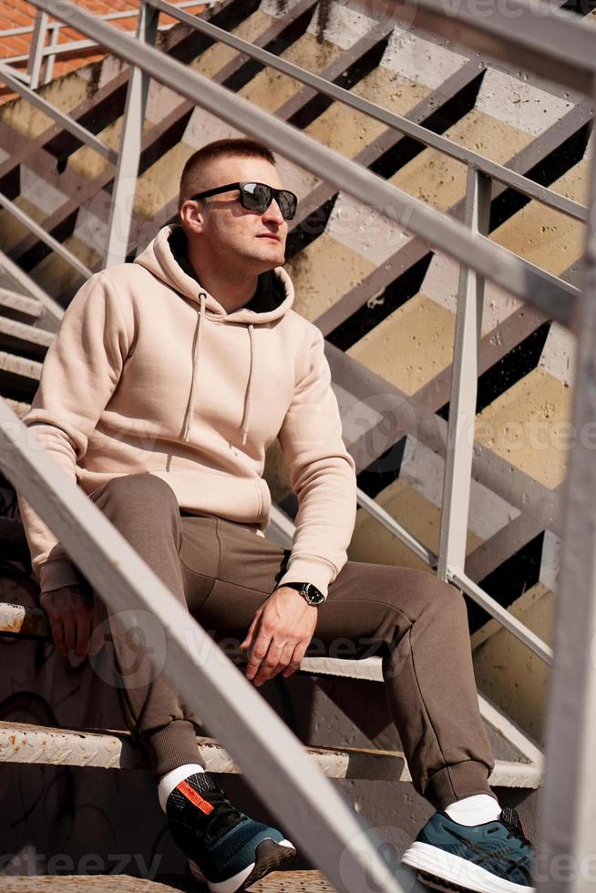 ein junger mann sitzt auf den treppen in der stadt. urbaner Stil foto