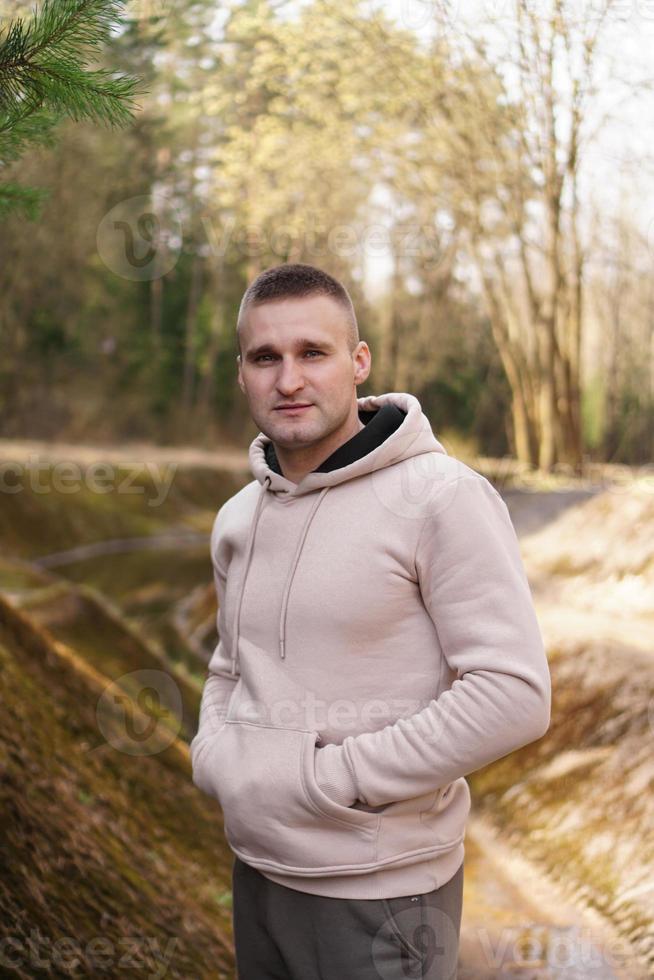 ein junger mann in einem bequemen anzug spaziert durch den wald foto