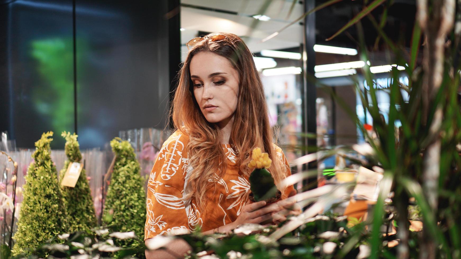 junge Frau kauft Blumen in einem Gartencenter foto